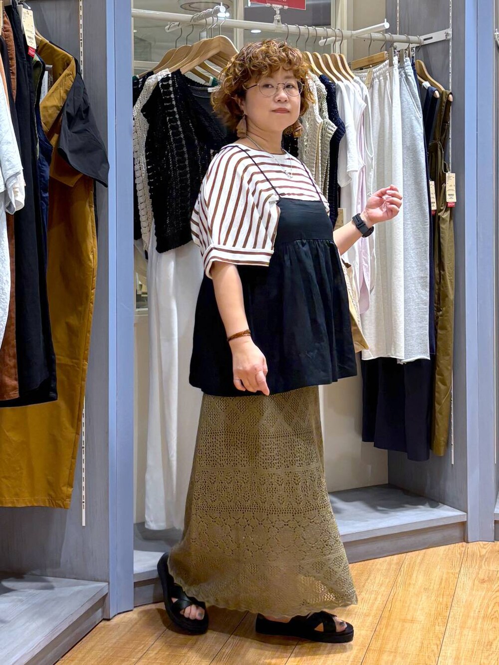 ブラック系のサンダル、ブラック系のキャミソール、グリーン系のスカートを着用したレディースの夏コーディネートの4枚目の写真