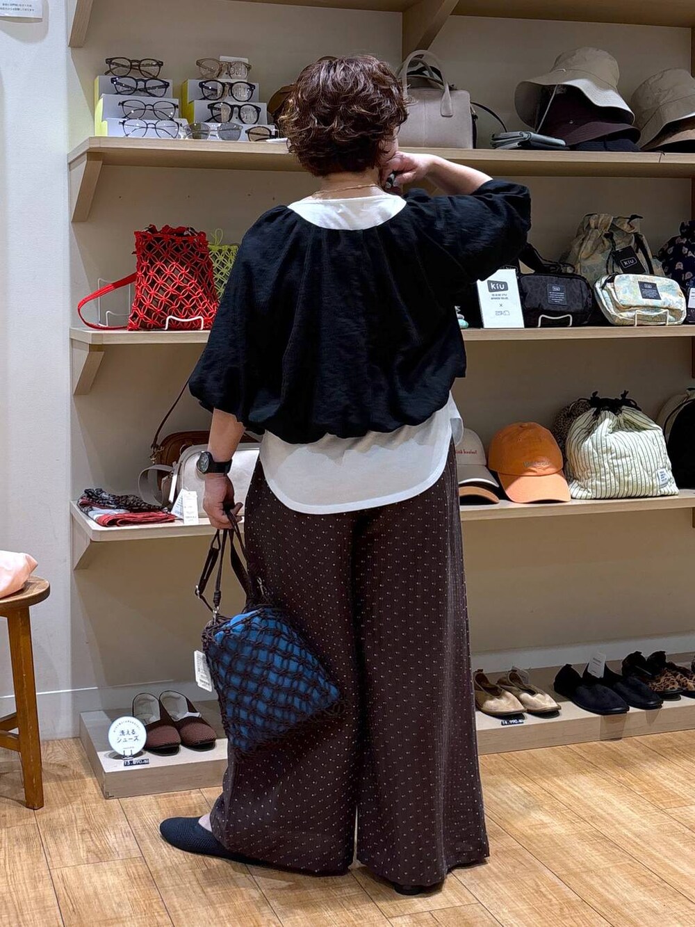 ブラウン系のショルダーバッグ、グレー系のパンプス、ホワイト系のTシャツ/カットソーを着用したレディースの春コーディネートの6枚目の写真