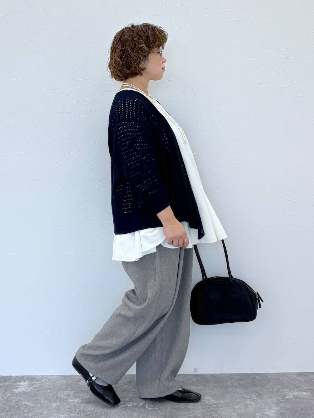 グレー系のその他パンツ、ホワイト系のシャツ/ブラウス、シルバー系のネックレスを着用したレディースの秋コーディネートの3枚目の写真