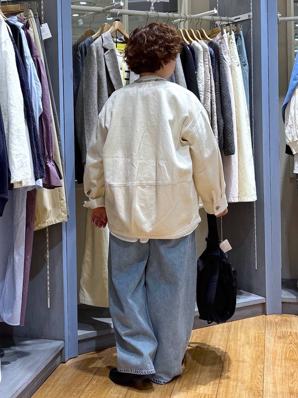 ブルー系のデニムパンツ、ベージュ系のノーカラージャケット、ベージュ系のニット/セーターを着用したレディースの冬コーディネートの6枚目の写真