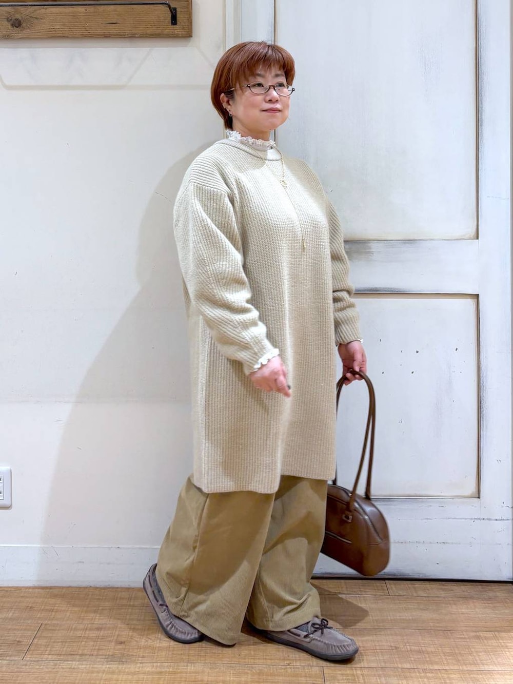 ベージュ系のその他パンツ、グレー系のモカシン/デッキシューズ、ブラウン系のトートバッグを着用したレディースの冬コーディネートの3枚目の写真