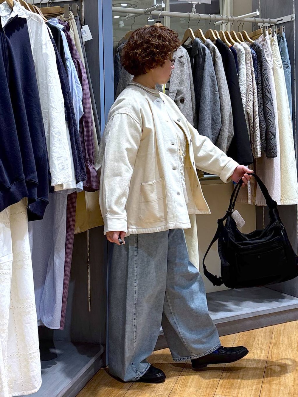 ブルー系のデニムパンツ、ベージュ系のノーカラージャケット、ベージュ系のニット/セーターを着用したレディースの冬コーディネートの5枚目の写真