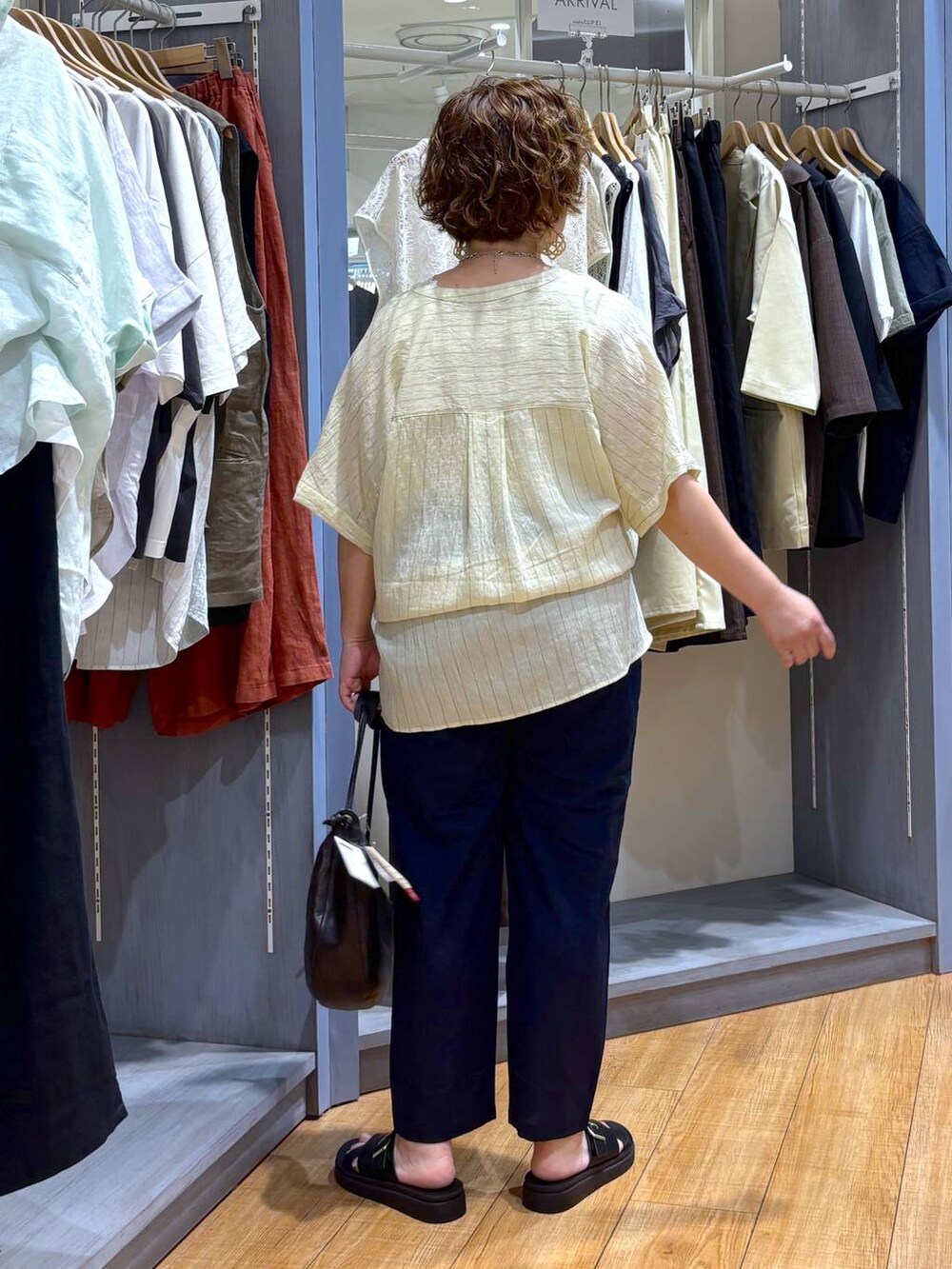 ブラック系のサンダル、ブラウン系のショルダーバッグ、ブルー系のその他パンツを着用したレディースの夏コーディネートの5枚目の写真