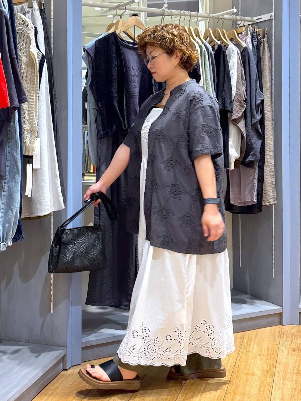 ブラック系のショルダーバッグ、ブラック系のサンダル、ブラウン系のタンクトップを着用したレディースの夏コーディネートの4枚目の写真