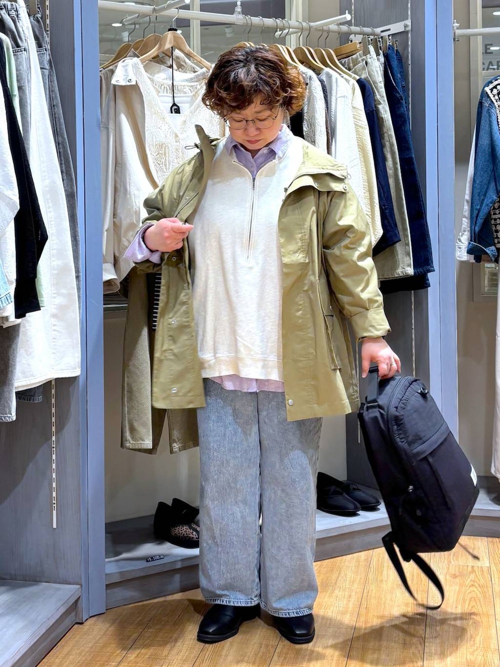 ベージュ系のスウェット、ブルー系のデニムパンツ、ベージュ系のブルゾンを着用したレディースの春コーディネートの3枚目の写真