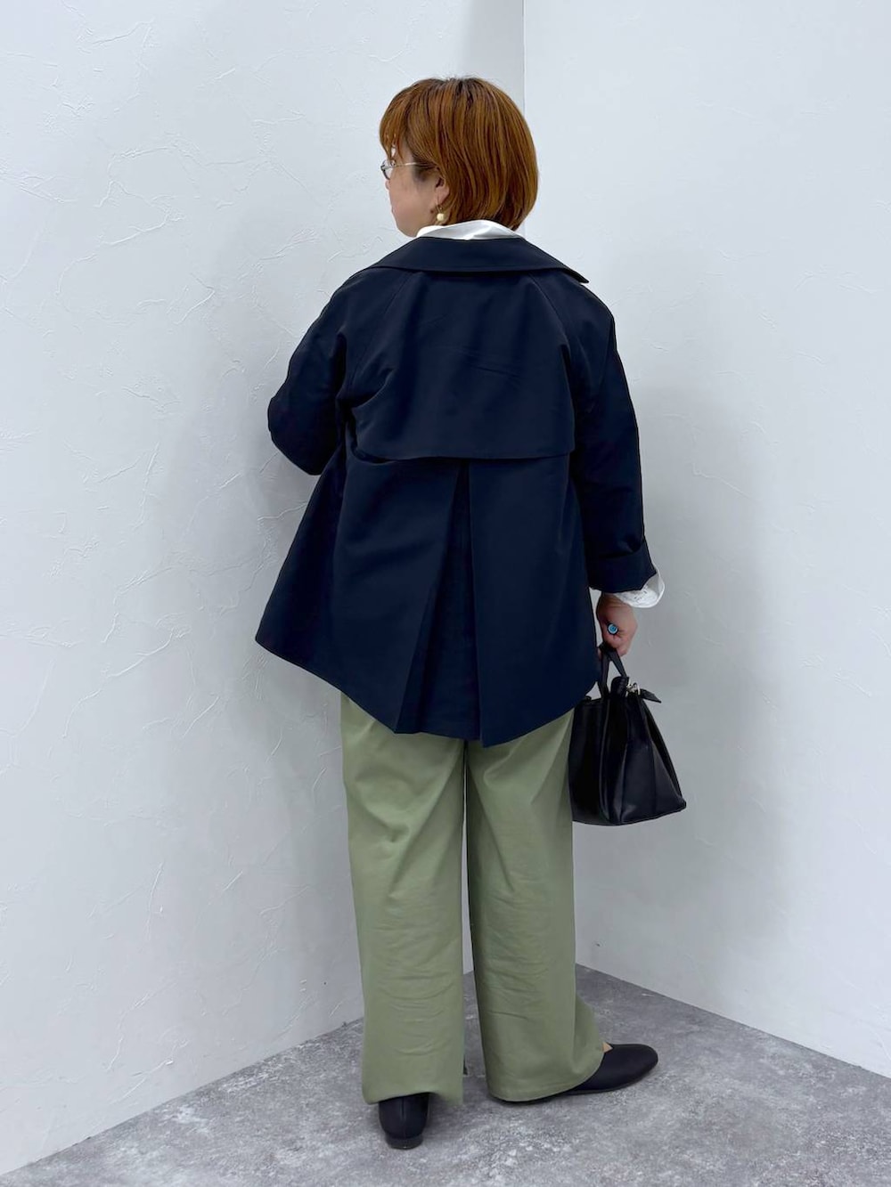 ブルー系のトレンチコート、ブラック系のショルダーバッグを着用したレディースの冬コーディネートの4枚目の写真