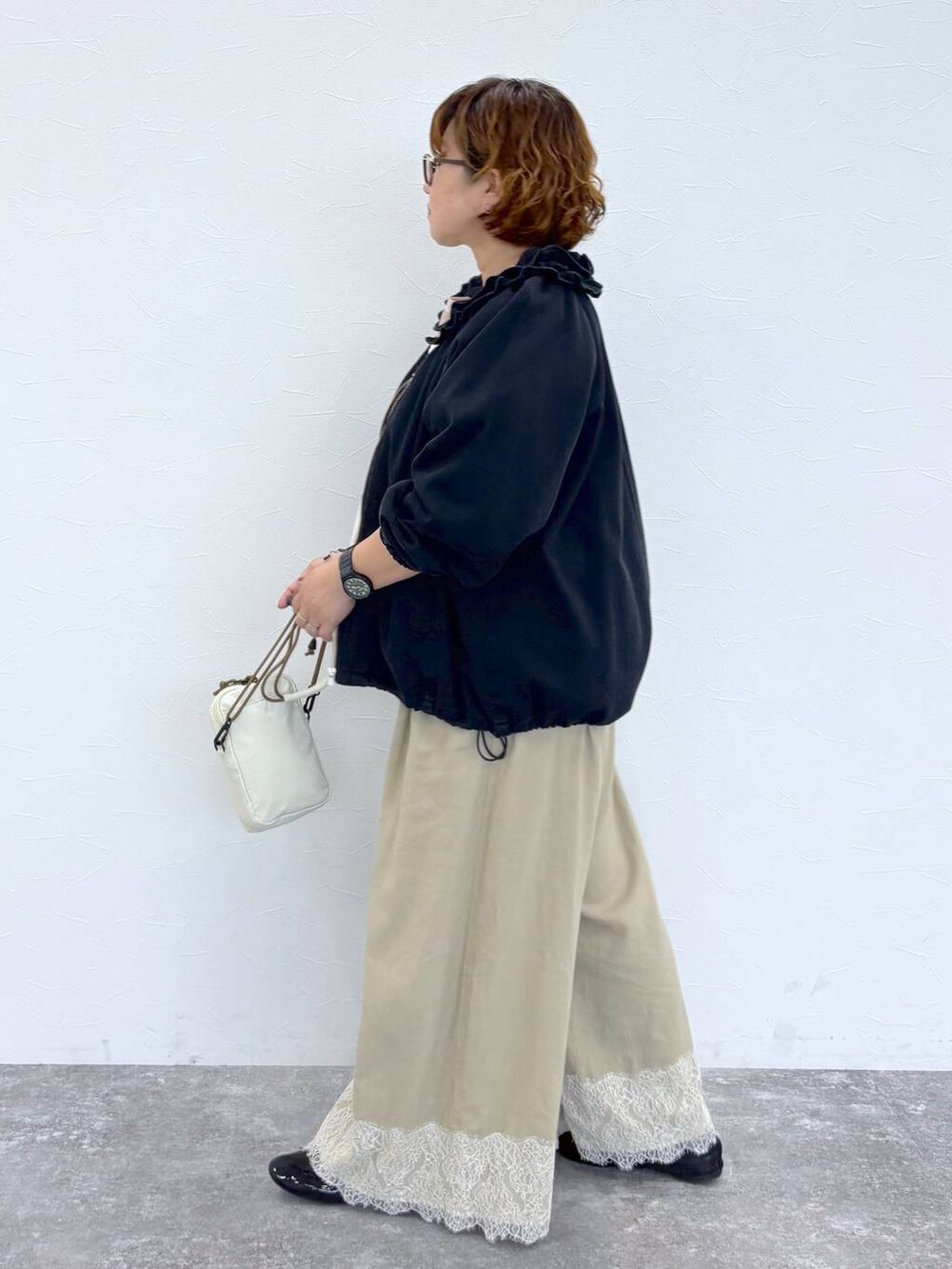 ベージュ系のその他パンツ、ブラック系のブルゾンを着用したレディースの夏コーディネートの3枚目の写真