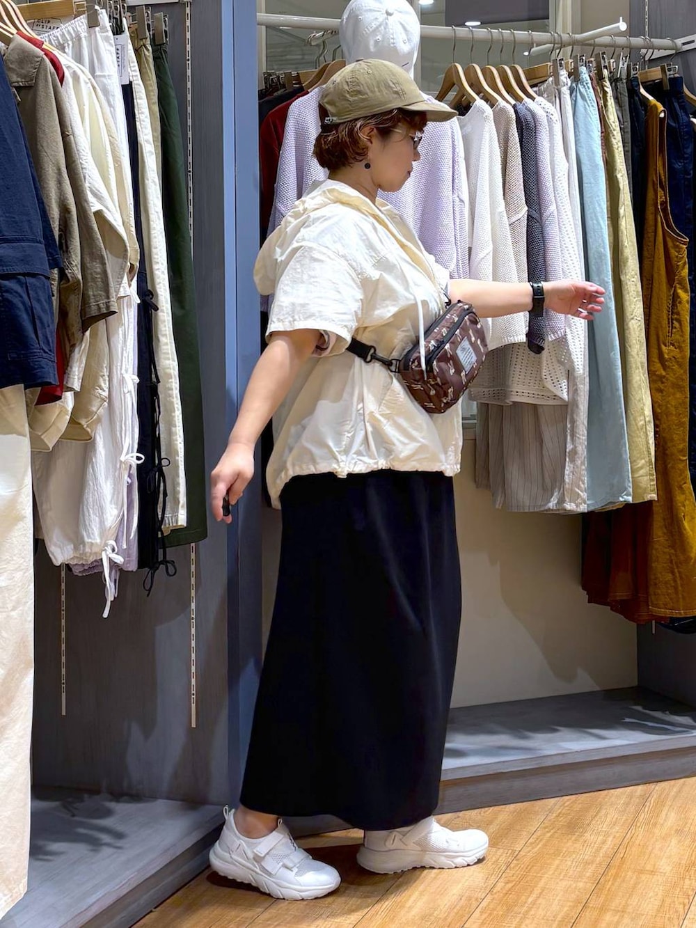 ブラック系のスカート、ホワイト系のスニーカー、その他のTシャツ/カットソーを着用したレディースの春コーディネートの4枚目の写真