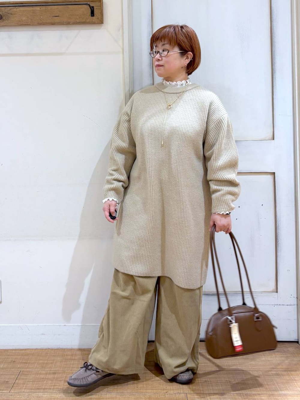 ベージュ系のその他パンツ、グレー系のモカシン/デッキシューズ、ブラウン系のトートバッグを着用したレディースの冬コーディネートの2枚目の写真