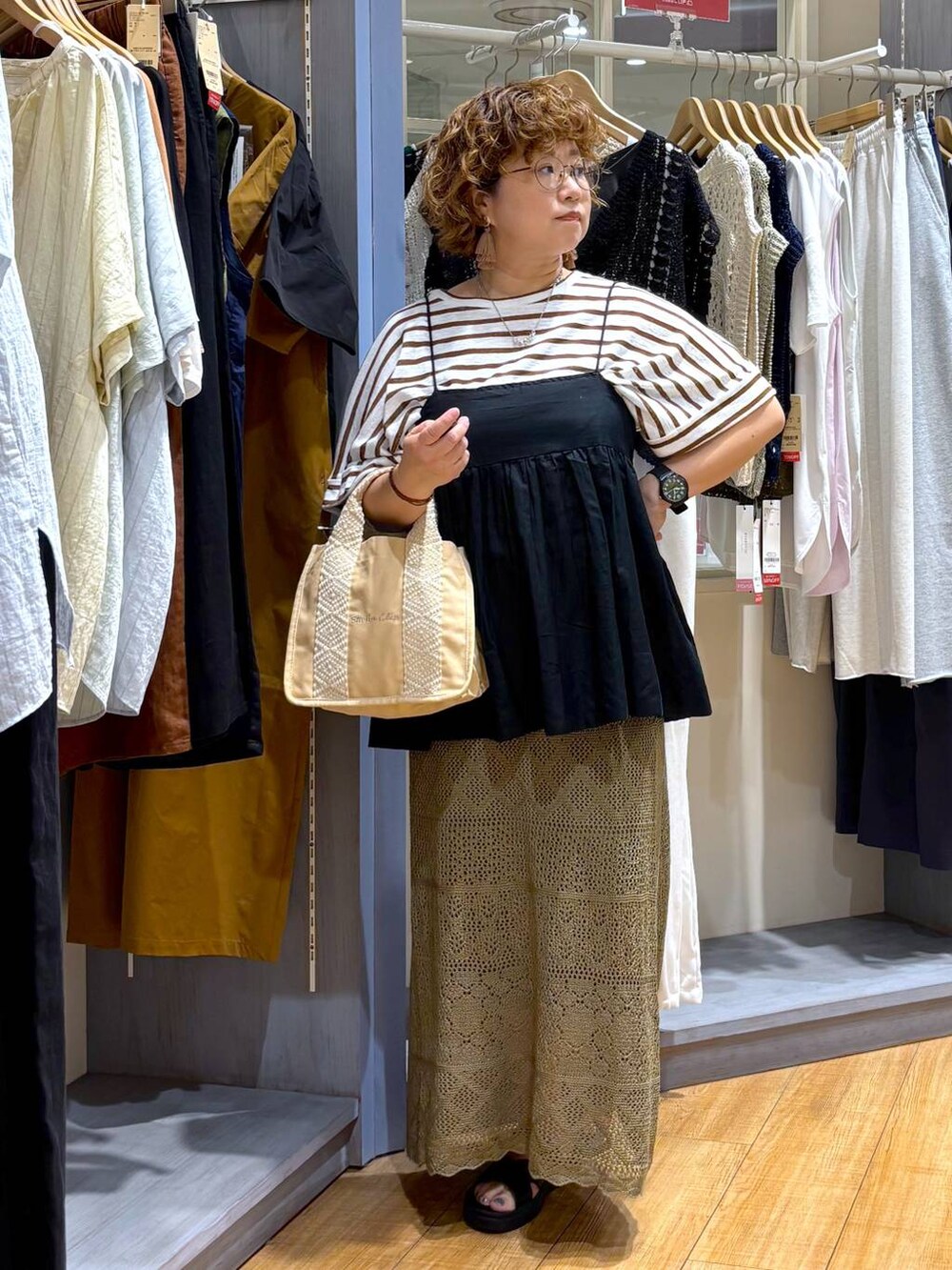 ブラック系のサンダル、ブラック系のキャミソール、グリーン系のスカートを着用したレディースの夏コーディネートの2枚目の写真