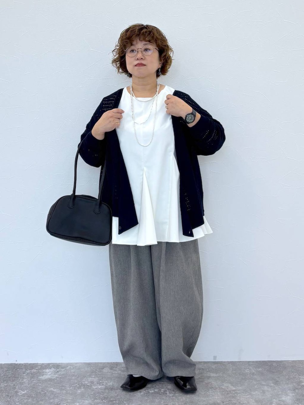 グレー系のその他パンツ、ホワイト系のシャツ/ブラウス、シルバー系のネックレスを着用したレディースの秋コーディネートの2枚目の写真