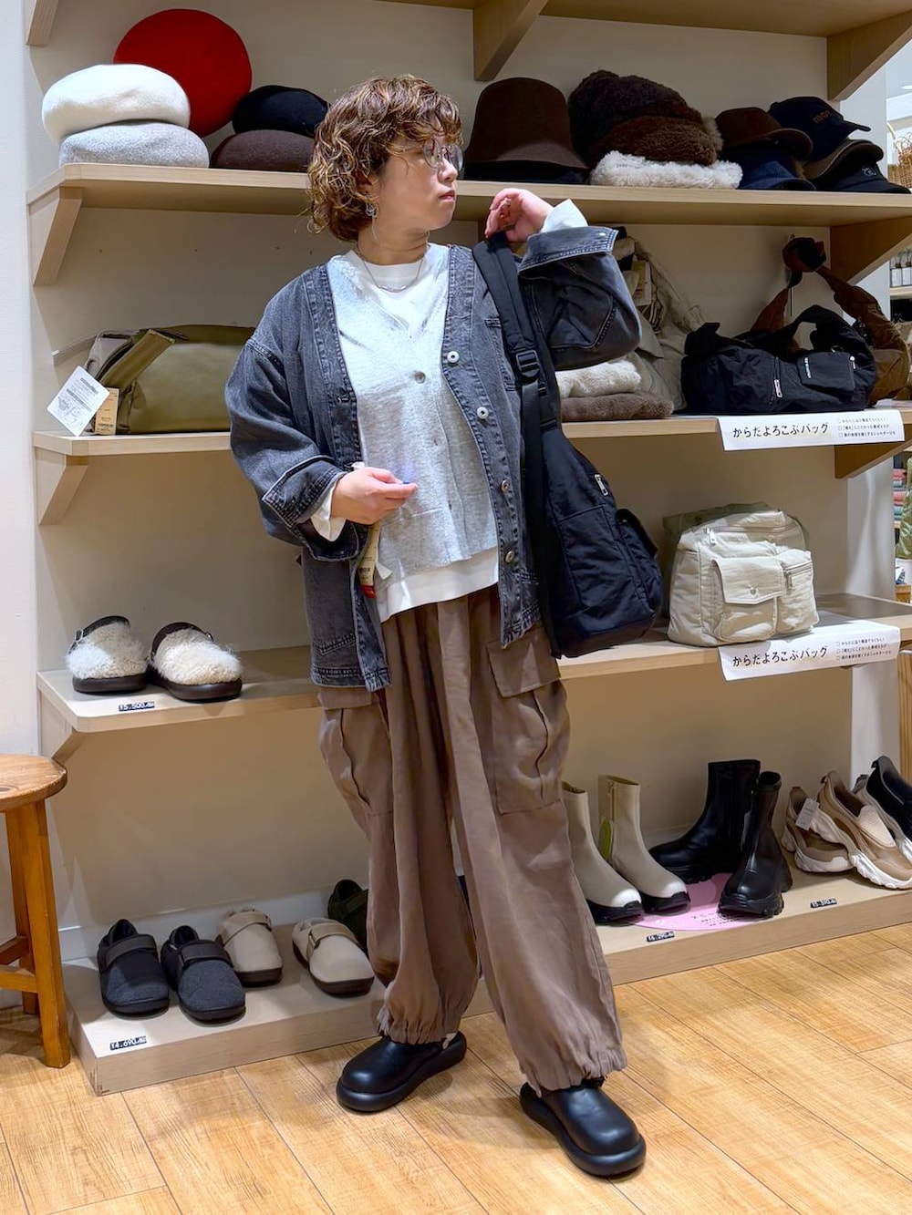 ブラック系のデニムジャケット、ブラウン系のその他パンツ、ブラック系のサンダルを着用したレディースの秋コーディネートの2枚目の写真