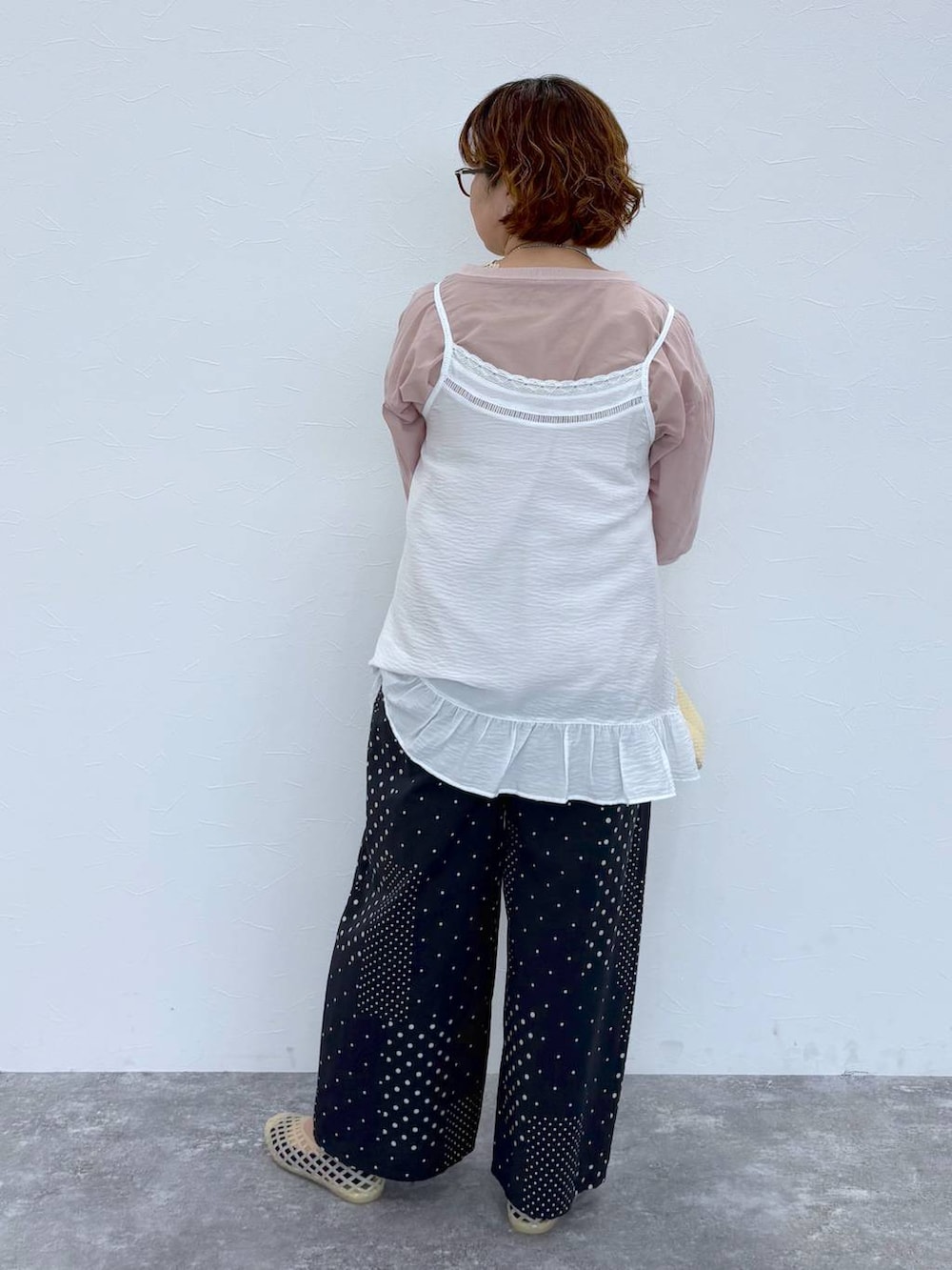 ベージュ系のショルダーバッグ、ベージュ系のパンプス、グリーン系のタンクトップを着用したレディースの夏コーディネートの6枚目の写真