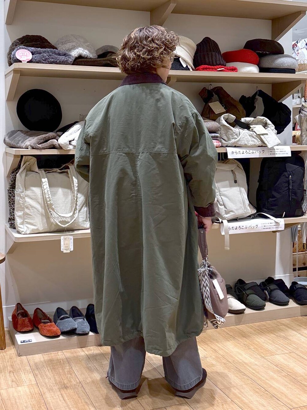 グレー系のデニムパンツ、グリーン系のモッズコート、ブラウン系のショルダーバッグを着用したレディースの秋コーディネートの6枚目の写真