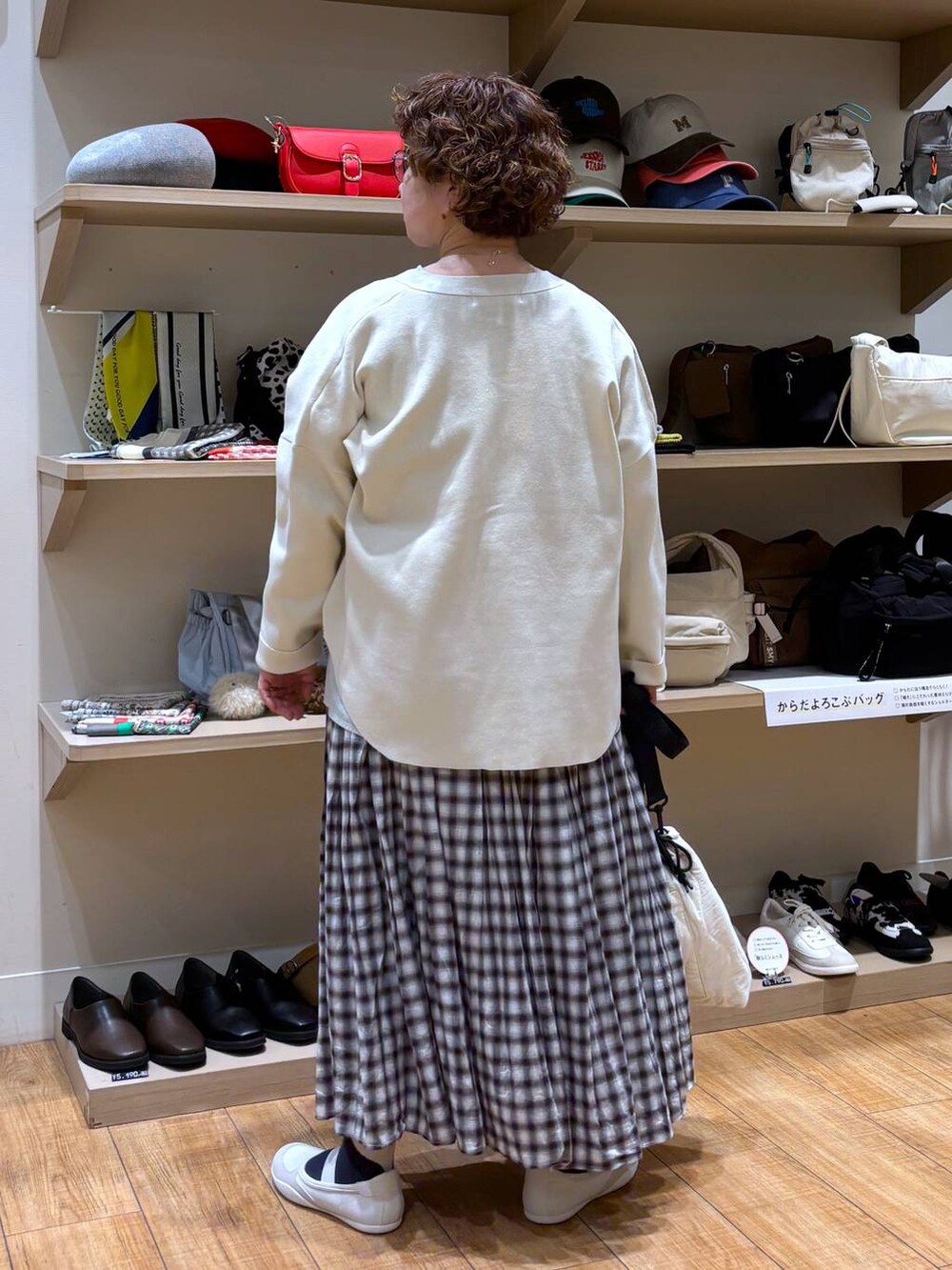 ベージュ系のショルダーバッグ、ブラウン系のスカート、ベージュ系のカーディガン/ボレロを着用したレディースの冬コーディネートの6枚目の写真