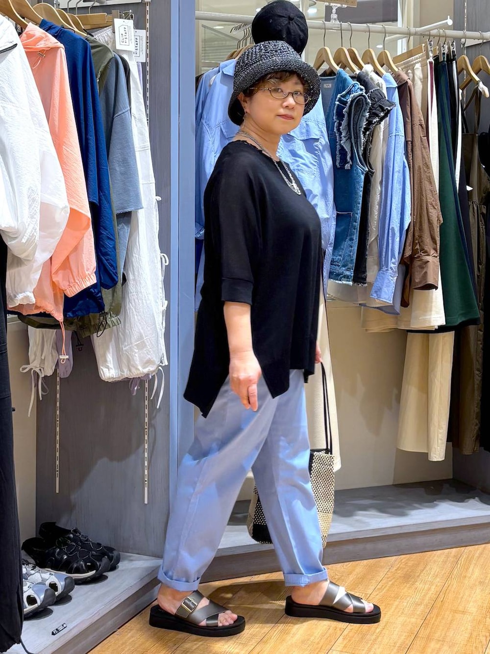 ブラック系のトートバッグ、その他のサンダル、ブルー系のその他パンツを着用したレディースの春コーディネートの3枚目の写真