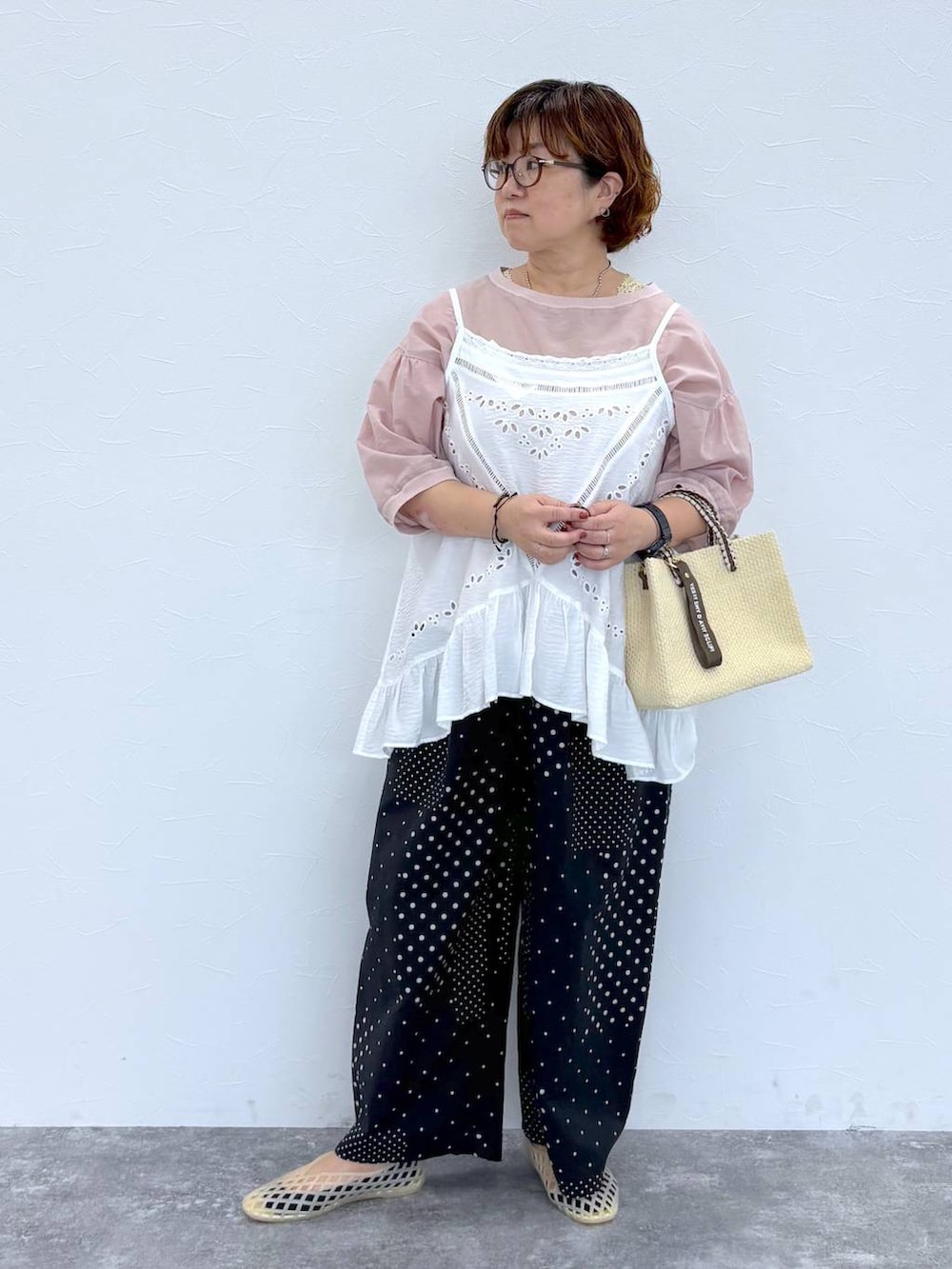 ベージュ系のショルダーバッグ、ベージュ系のパンプス、グリーン系のタンクトップを着用したレディースの夏コーディネートの2枚目の写真