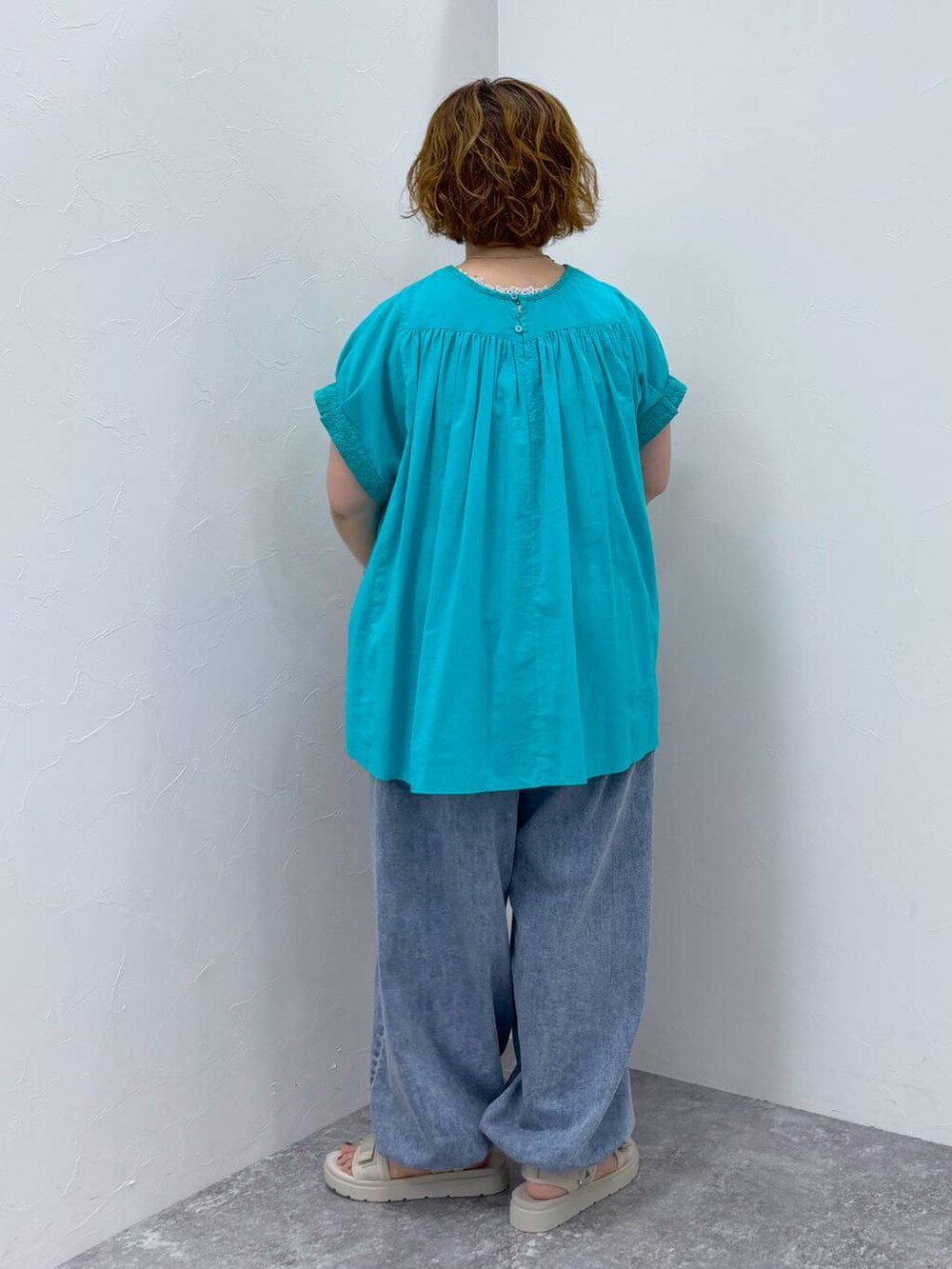 ホワイト系のサンダル、ブルー系のデニムパンツ、その他のネックレスを着用したレディースの夏コーディネートの5枚目の写真