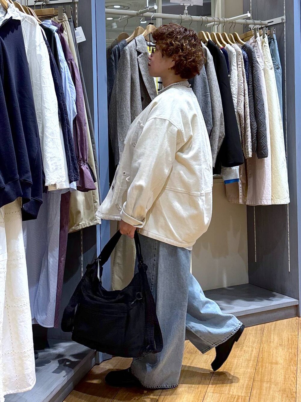 ブルー系のデニムパンツ、ベージュ系のノーカラージャケット、ベージュ系のニット/セーターを着用したレディースの冬コーディネートの4枚目の写真