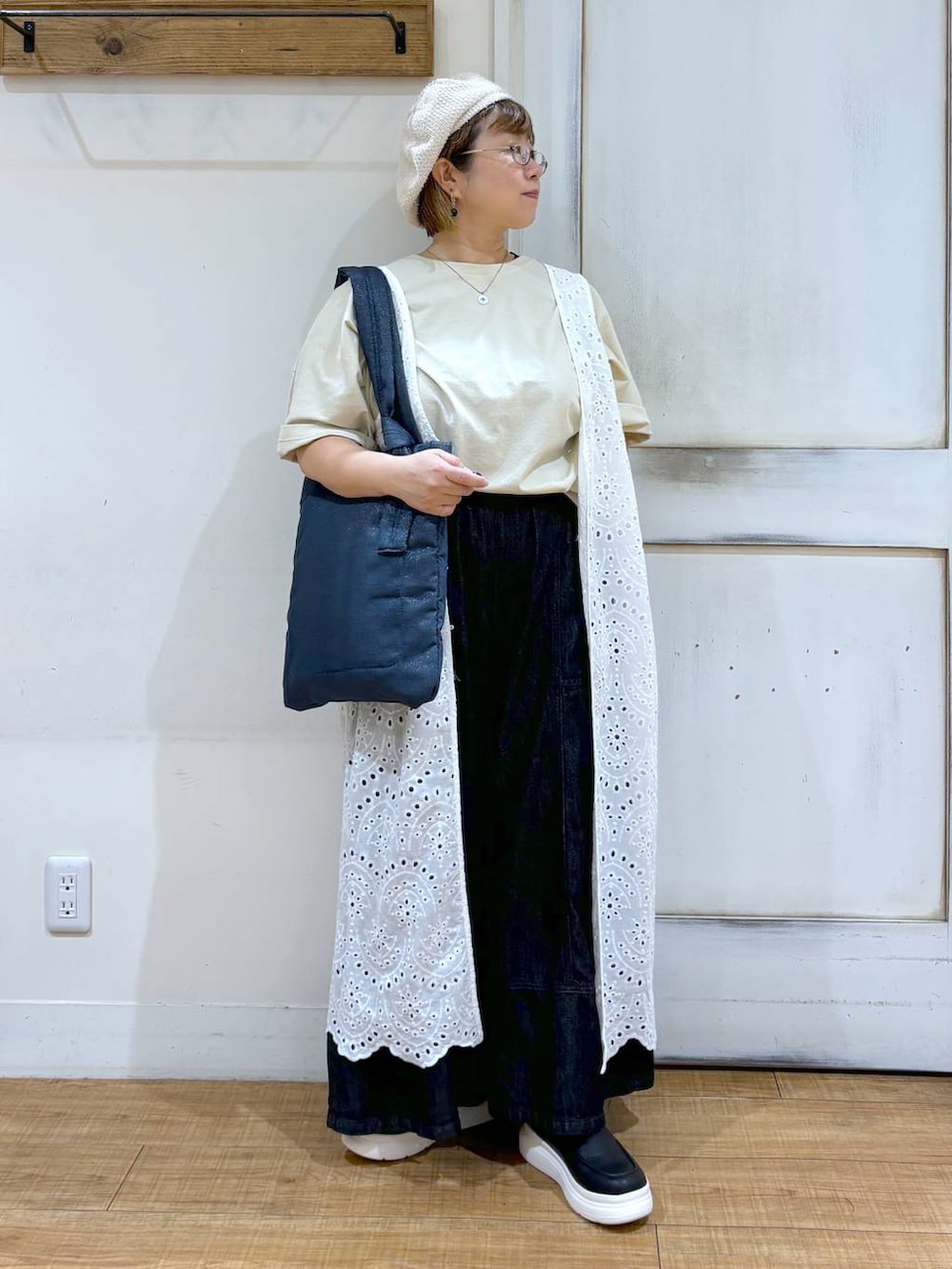 ブラック系のデニムパンツ、ブラック系のスリッポン、ベージュ系のTシャツ/カットソーを着用したレディースの秋コーディネートの2枚目の写真