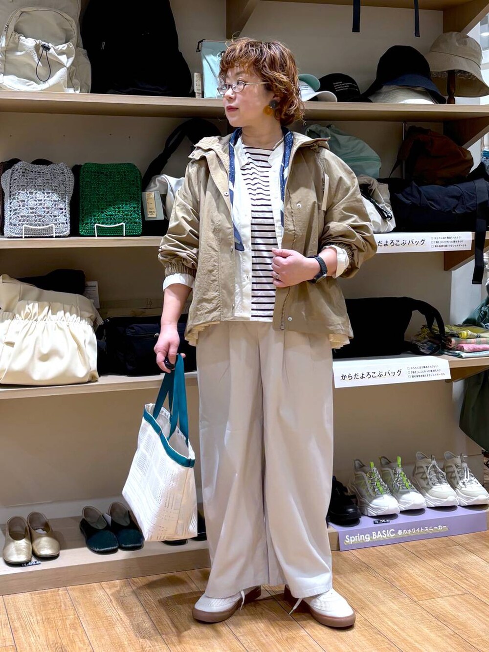 ベージュ系のマウンテンパーカー、ベージュ系のシャツ/ブラウス、ベージュ系のエコバッグ/サブバッグを着用したレディースの春コーディネートの5枚目の写真