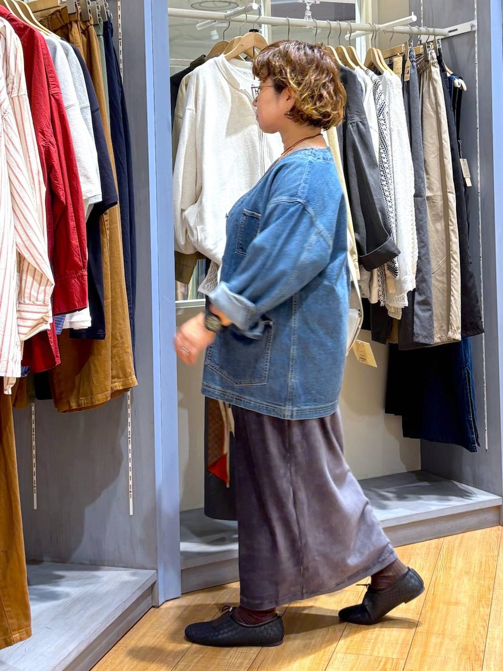 ブルー系のデニムジャケット、ブラック系のパンプス、ベージュ系のショルダーバッグを着用したレディースの秋コーディネートの2枚目の写真