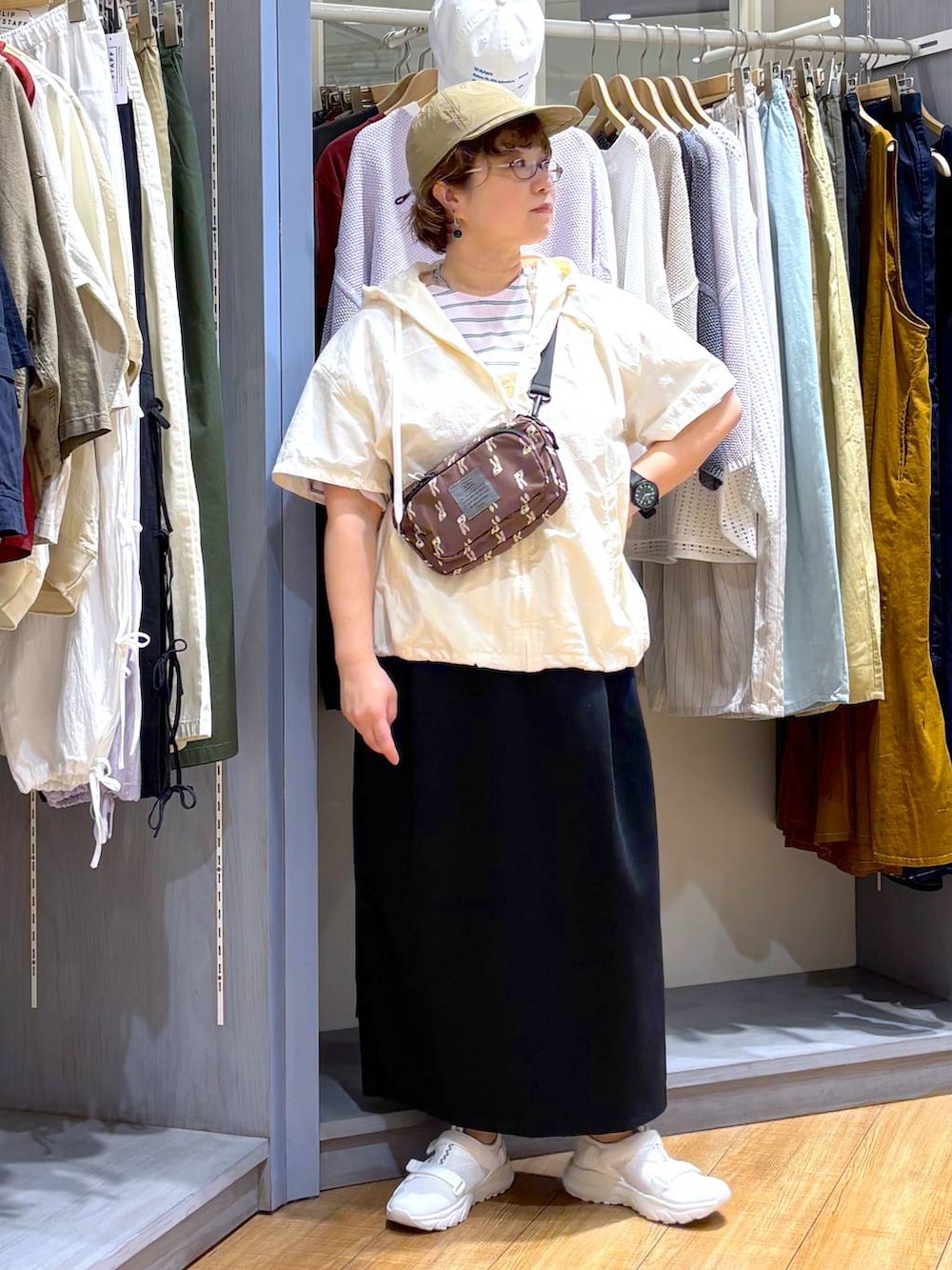 ブラック系のスカート、ホワイト系のスニーカー、その他のTシャツ/カットソーを着用したレディースの春コーディネートの2枚目の写真