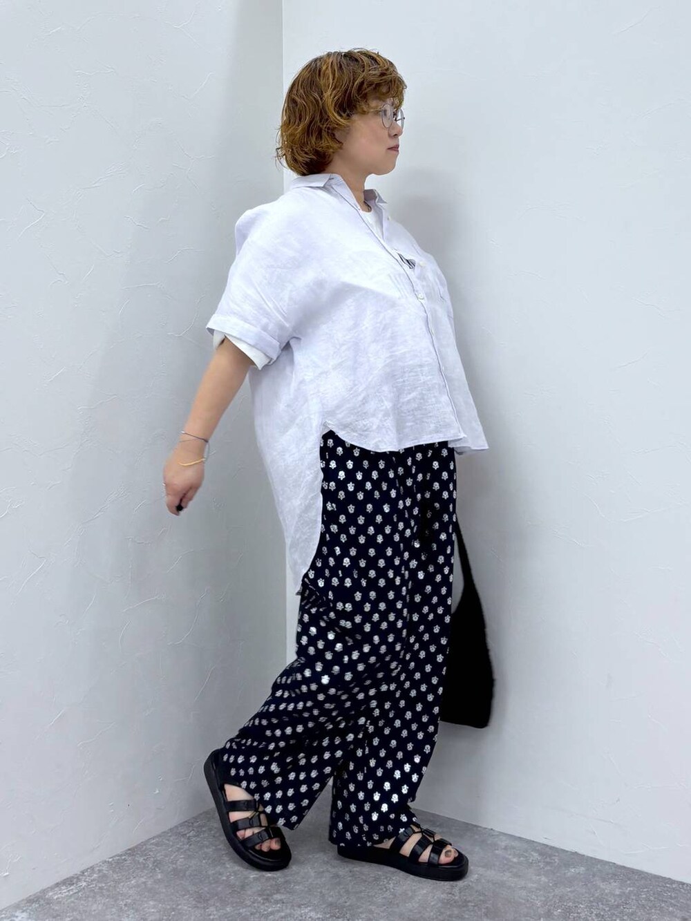 ホワイト系のTシャツ/カットソー、ブラック系のトートバッグ、ブラック系のサンダルを着用したレディースの夏コーディネートの3枚目の写真