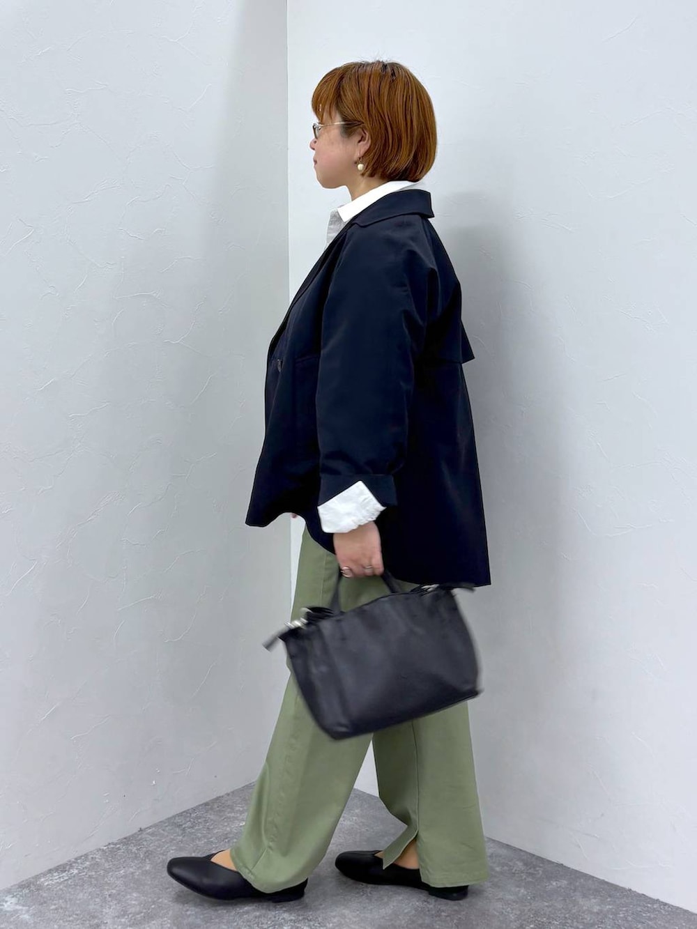 ブルー系のトレンチコート、ブラック系のショルダーバッグを着用したレディースの冬コーディネートの3枚目の写真