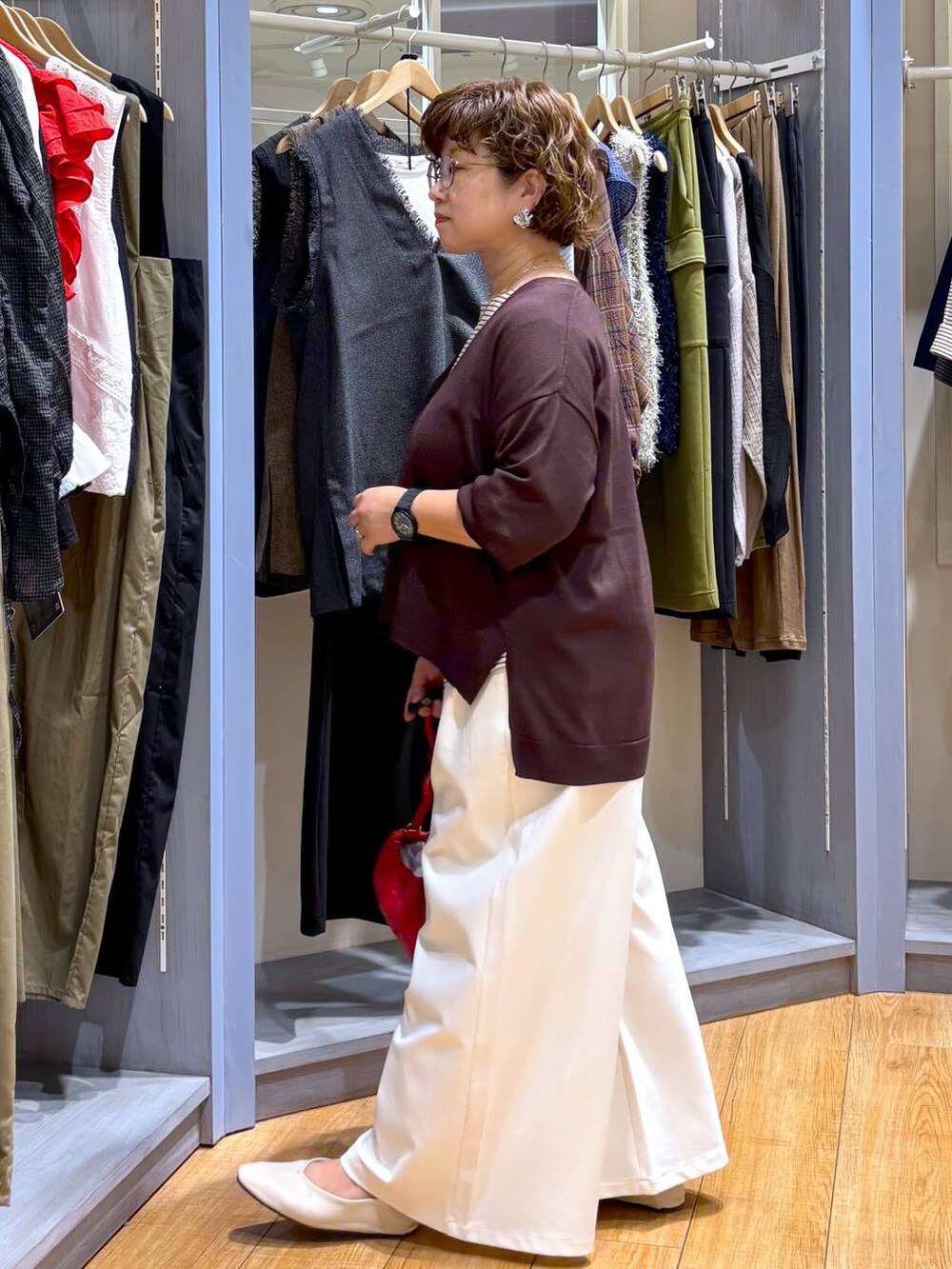 ブラウン系のショルダーバッグ、ベージュ系のパンプス、ホワイト系のTシャツ/カットソーを着用したレディースの秋コーディネートの4枚目の写真