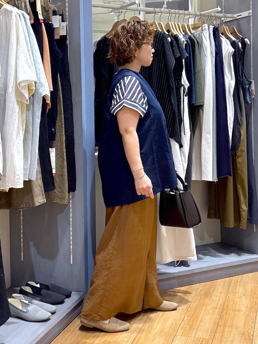 ブルー系のシャツ/ブラウス、ベージュ系のパンプス、ブラウン系のショルダーバッグを着用したレディースの夏コーディネートの4枚目の写真