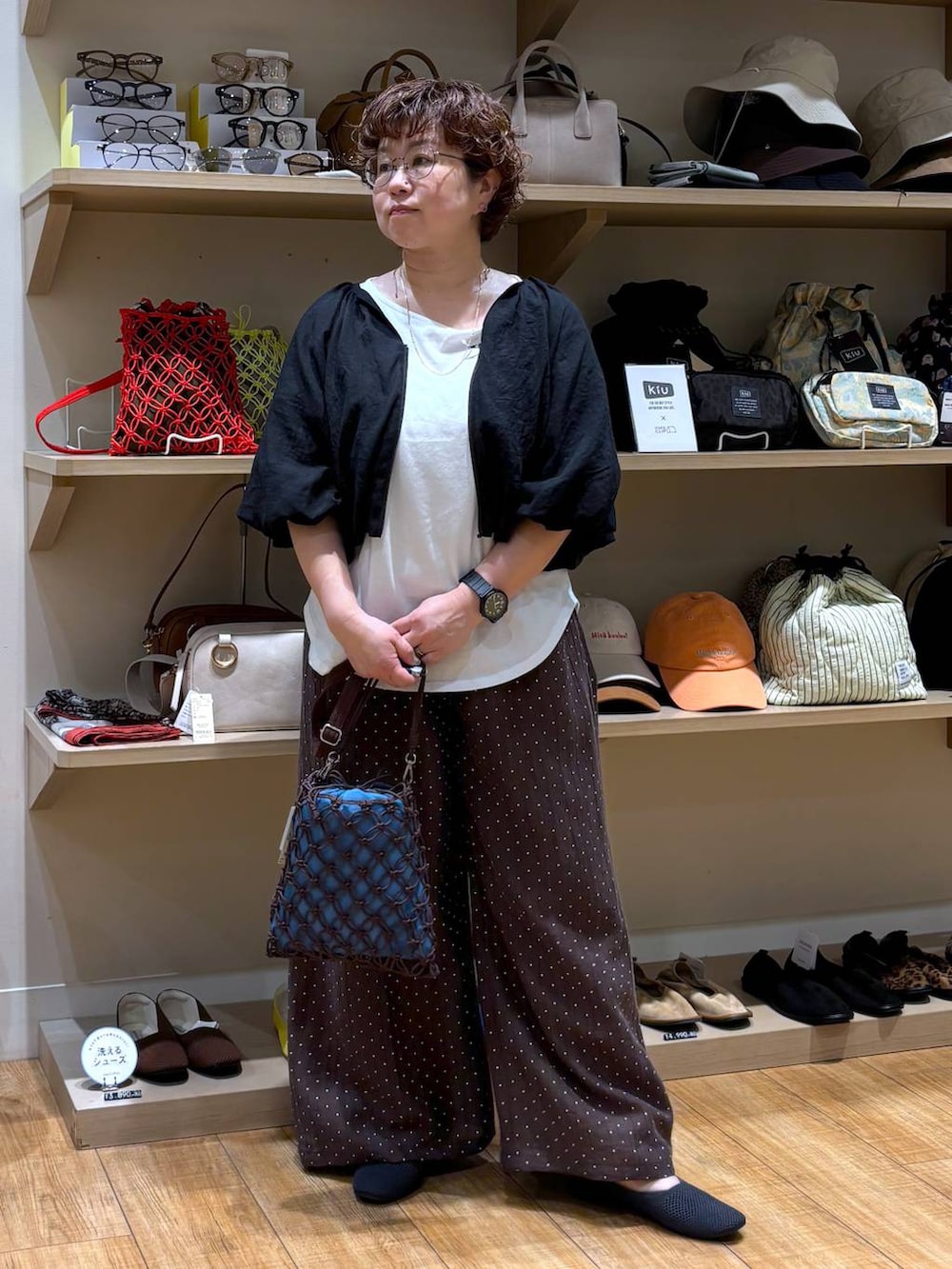 ブラウン系のショルダーバッグ、グレー系のパンプス、ホワイト系のTシャツ/カットソーを着用したレディースの春コーディネートの2枚目の写真
