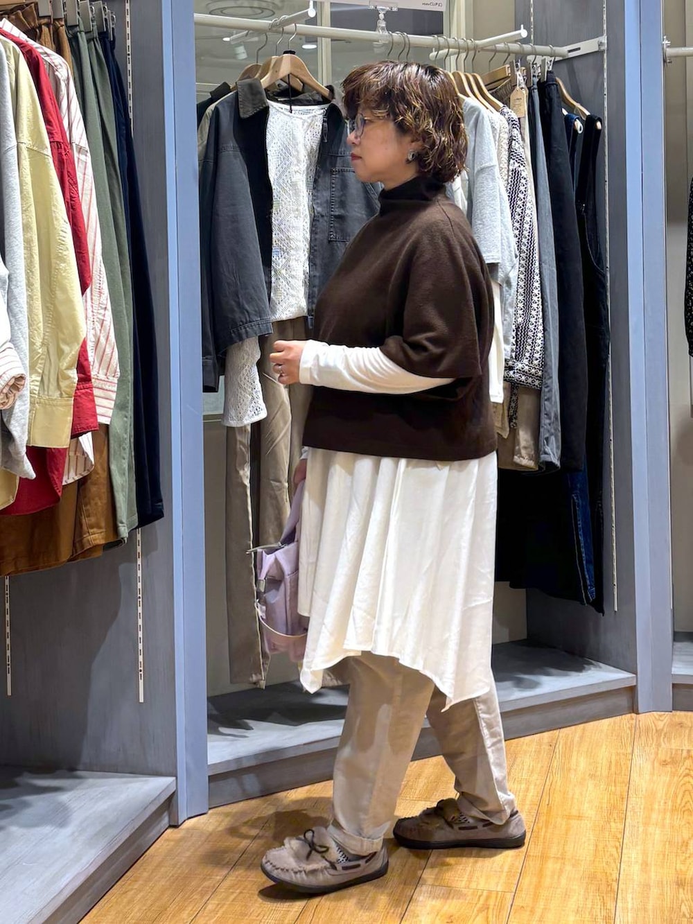 グレー系のモカシン/デッキシューズ、ブラウン系のベスト、ベージュ系のチュニックを着用したレディースの秋コーディネートの4枚目の写真