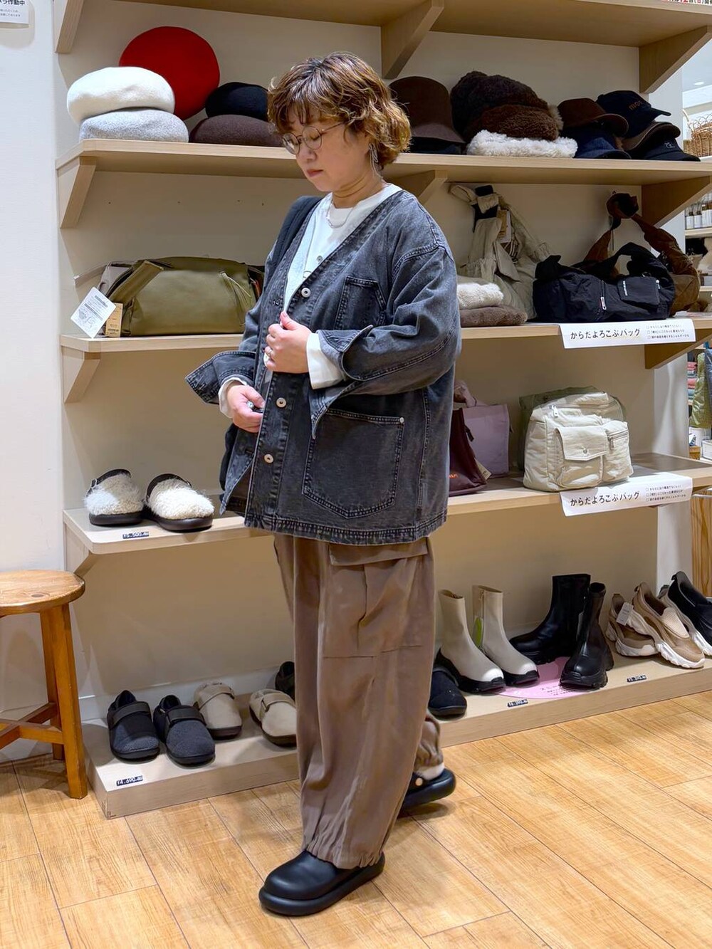 ブラック系のデニムジャケット、ブラウン系のその他パンツ、ブラック系のサンダルを着用したレディースの秋コーディネートの3枚目の写真