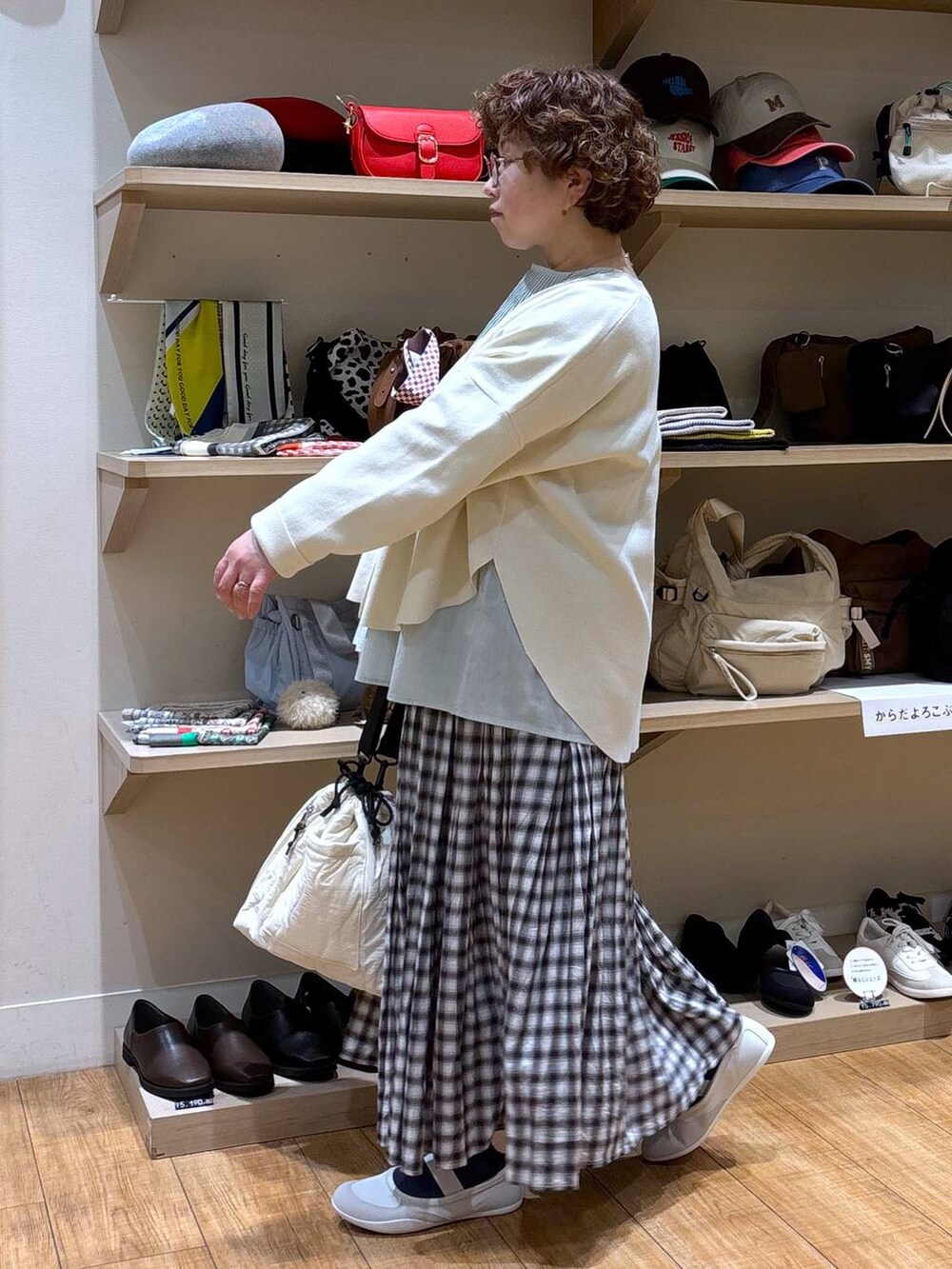 ベージュ系のショルダーバッグ、ブラウン系のスカート、ベージュ系のカーディガン/ボレロを着用したレディースの冬コーディネートの5枚目の写真