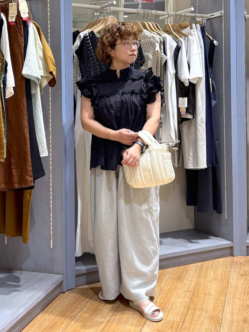 ホワイト系のサンダル、ブラック系のシャツ/ブラウス、グリーン系のその他パンツを着用したレディースの夏コーディネートの3枚目の写真