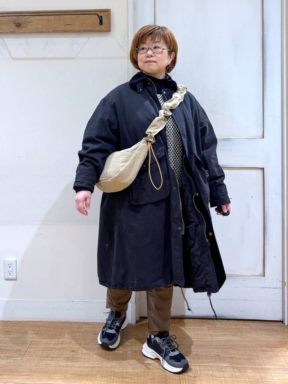 ブラウン系のその他パンツ、ブラック系のスニーカー、ベージュ系のショルダーバッグを着用したレディースの冬コーディネートの3枚目の写真