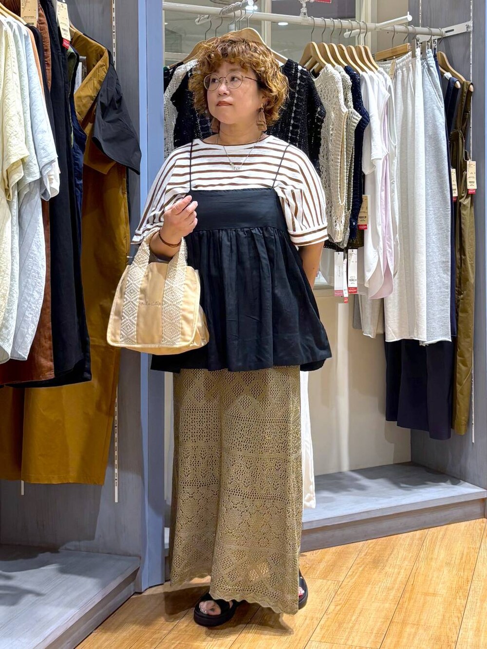 ブラック系のサンダル、ブラック系のキャミソール、グリーン系のスカートを着用したレディースの夏コーディネートの3枚目の写真