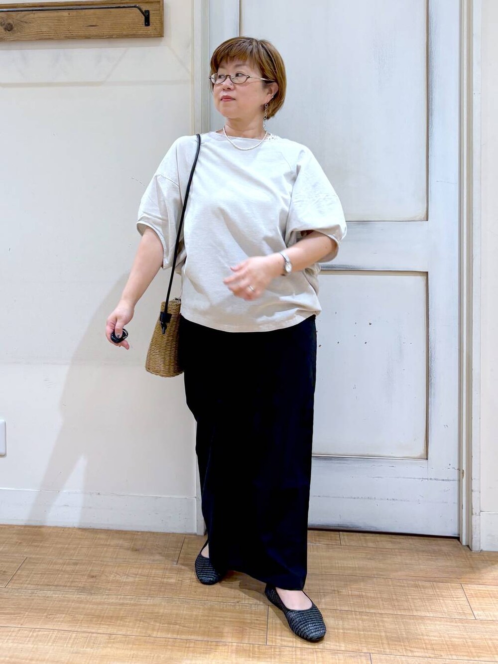 ブラウン系のショルダーバッグ、ブラック系のその他パンツ、グレー系のシャツ/ブラウスを着用したレディースの夏コーディネートの2枚目の写真