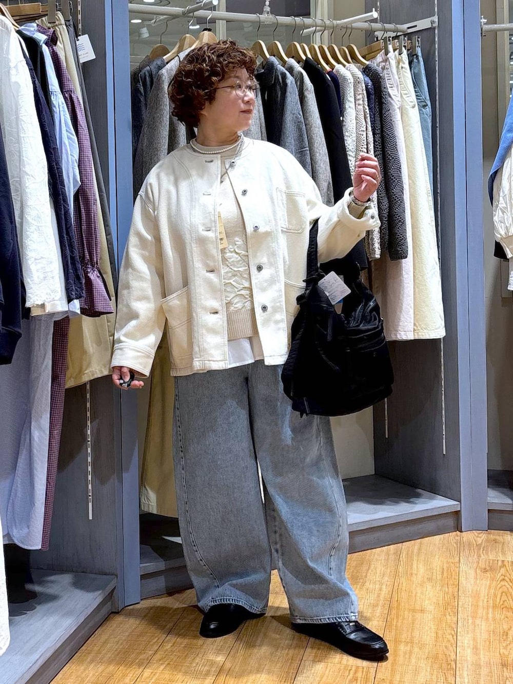 ブルー系のデニムパンツ、ベージュ系のノーカラージャケット、ベージュ系のニット/セーターを着用したレディースの冬コーディネートの3枚目の写真