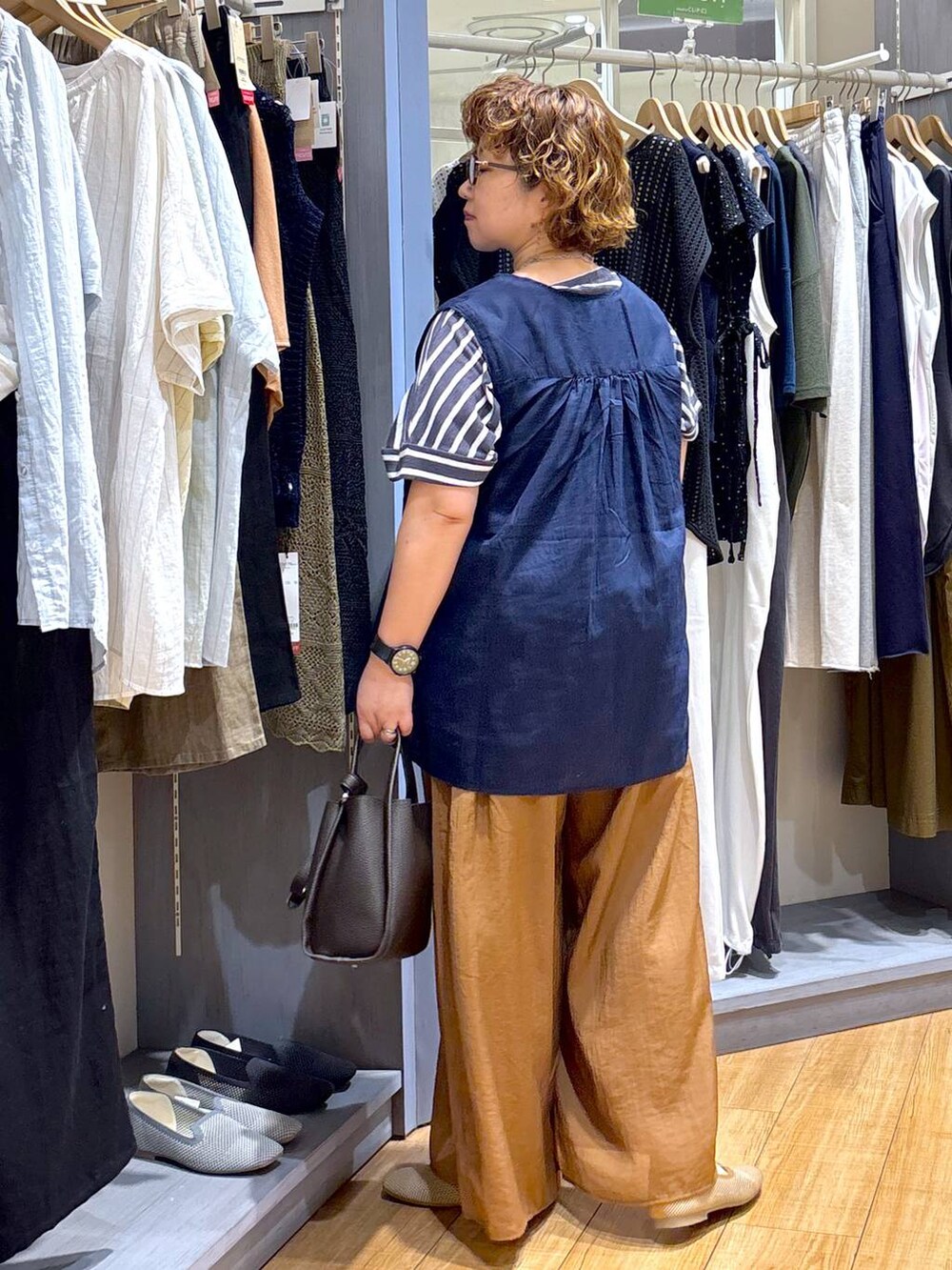 ブルー系のシャツ/ブラウス、ベージュ系のパンプス、ブラウン系のショルダーバッグを着用したレディースの夏コーディネートの5枚目の写真