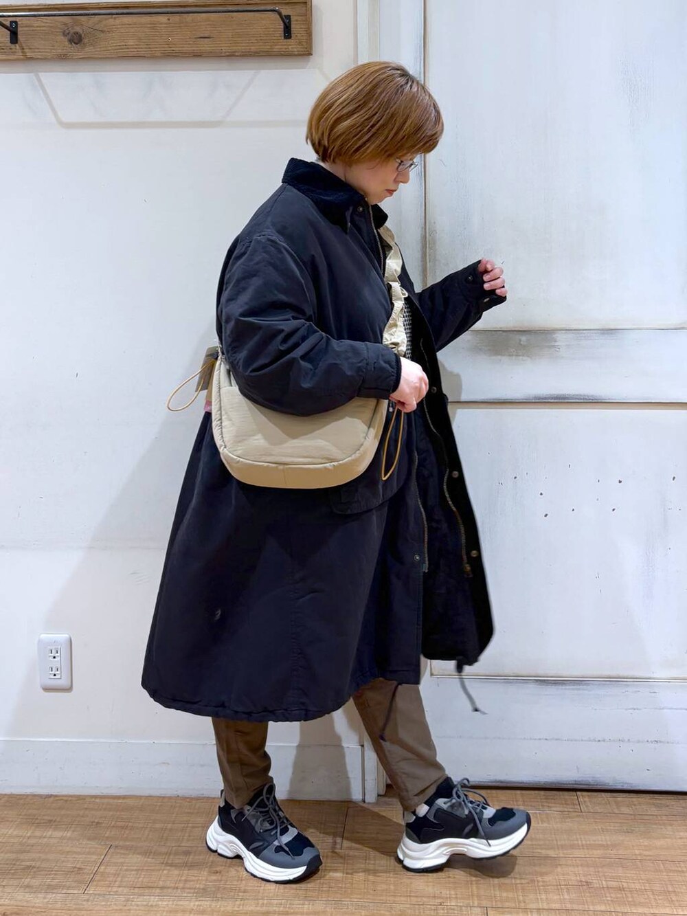 ブラウン系のその他パンツ、ブラック系のスニーカー、ベージュ系のショルダーバッグを着用したレディースの冬コーディネートの4枚目の写真