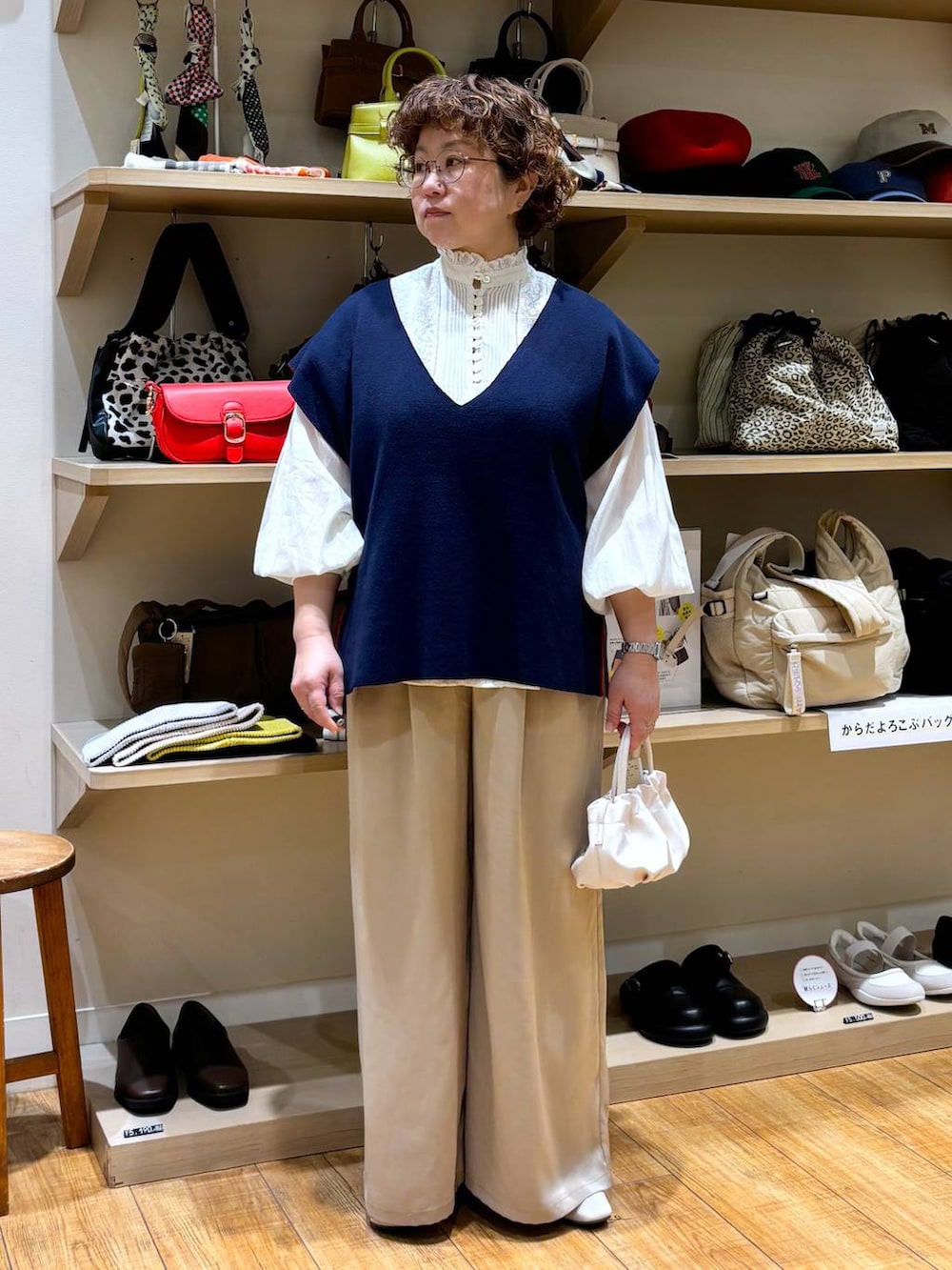 ホワイト系のシャツ/ブラウス、ベージュ系のショルダーバッグ、ベージュ系のパンプスを着用したレディースの冬コーディネートの2枚目の写真