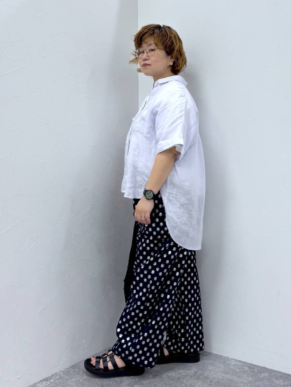 ホワイト系のTシャツ/カットソー、ブラック系のトートバッグ、ブラック系のサンダルを着用したレディースの夏コーディネートの2枚目の写真