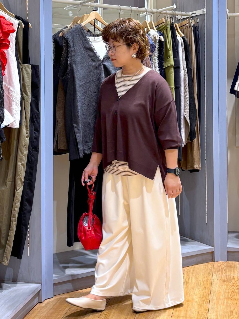 ブラウン系のショルダーバッグ、ベージュ系のパンプス、ホワイト系のTシャツ/カットソーを着用したレディースの秋コーディネートの3枚目の写真