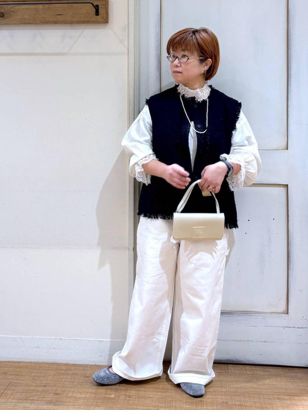 ホワイト系のサロペット/オーバーオール、ホワイト系のシャツ/ブラウス、ブルー系のベストを着用したレディースの冬コーディネートの2枚目の写真