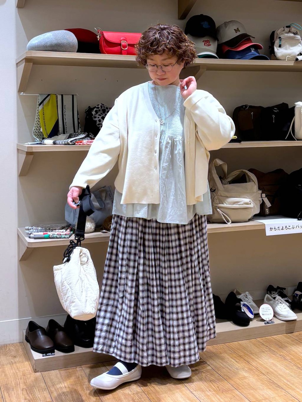 ベージュ系のショルダーバッグ、ブラウン系のスカート、ベージュ系のカーディガン/ボレロを着用したレディースの冬コーディネートの3枚目の写真