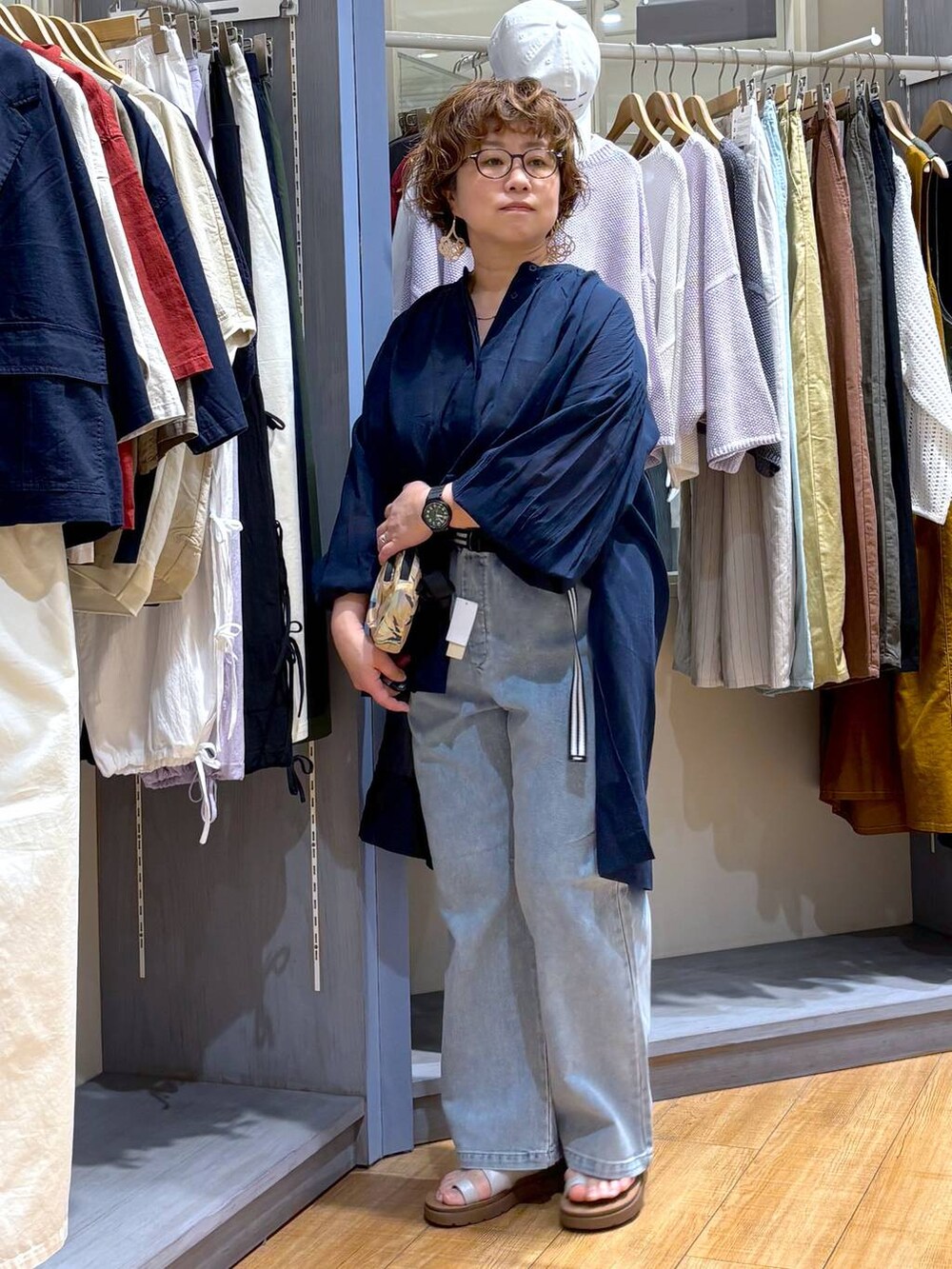 その他のサンダル、ブルー系のデニムパンツ、ベージュ系のショルダーバッグを着用したレディースの春コーディネートの4枚目の写真