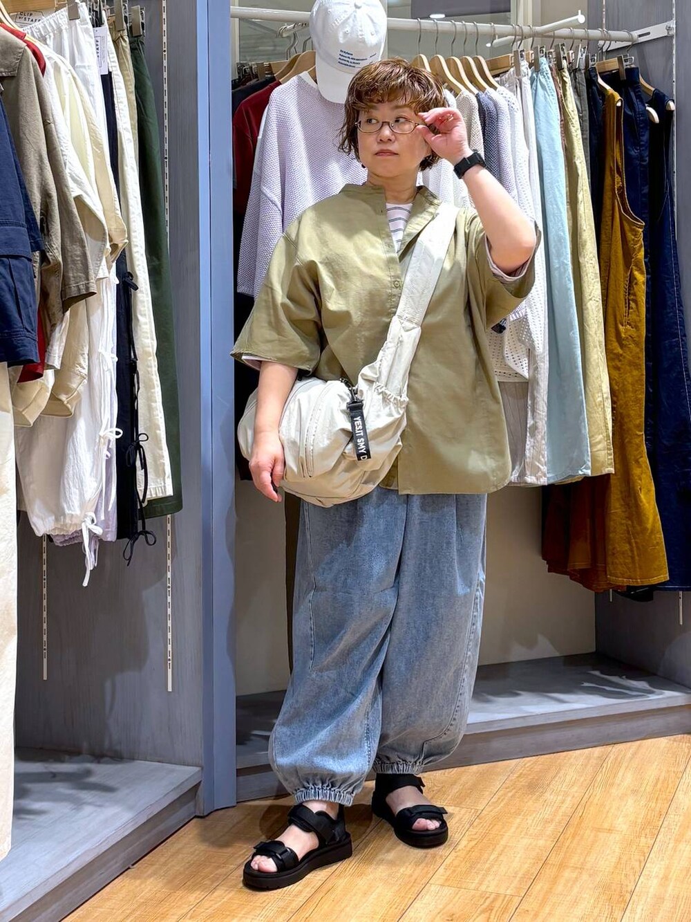 ブラック系のサンダル、ベージュ系のショルダーバッグ、その他のTシャツ/カットソーを着用したレディースの春コーディネートの2枚目の写真