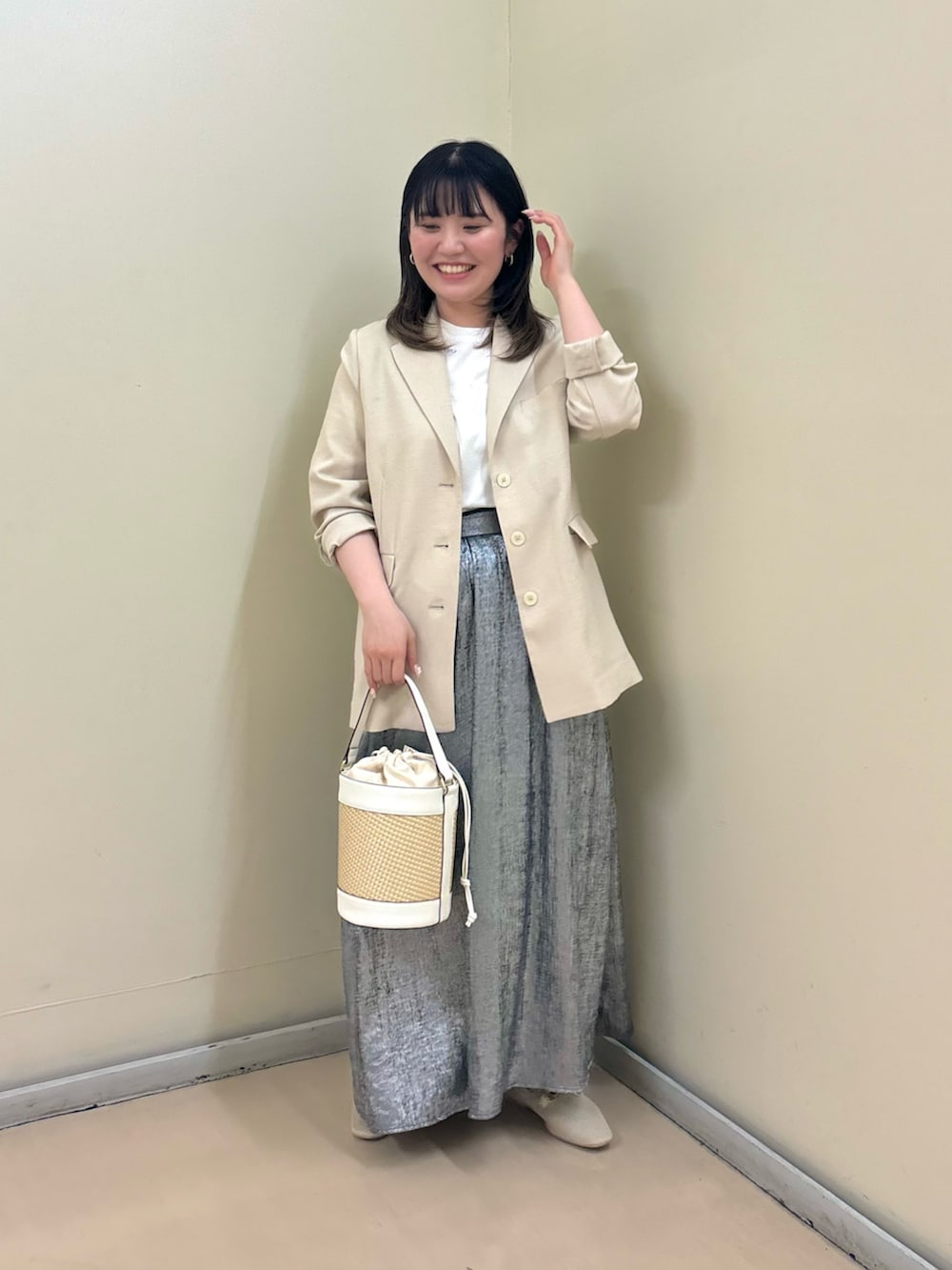 ホワイト系のテーラードジャケット、ホワイト系のショルダーバッグ、ホワイト系のローファーを着用したレディースの春コーディネートの2枚目の写真